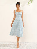 Front view of a woman in a white floral print midi dress with spaghetti straps and a flared skirt.