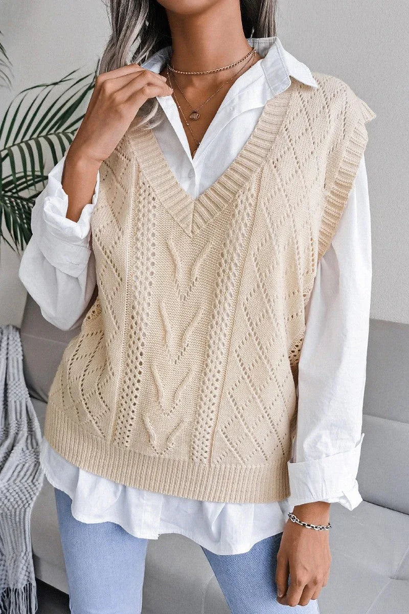 Woman wearing a beige cable knit V-neck sleeveless sweater vest over a white collared shirt.