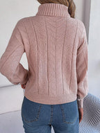 Back view of a woman in a pink cable knit turtleneck sweater