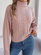 Woman wearing a pink cable knit turtleneck sweater with blue jeans
