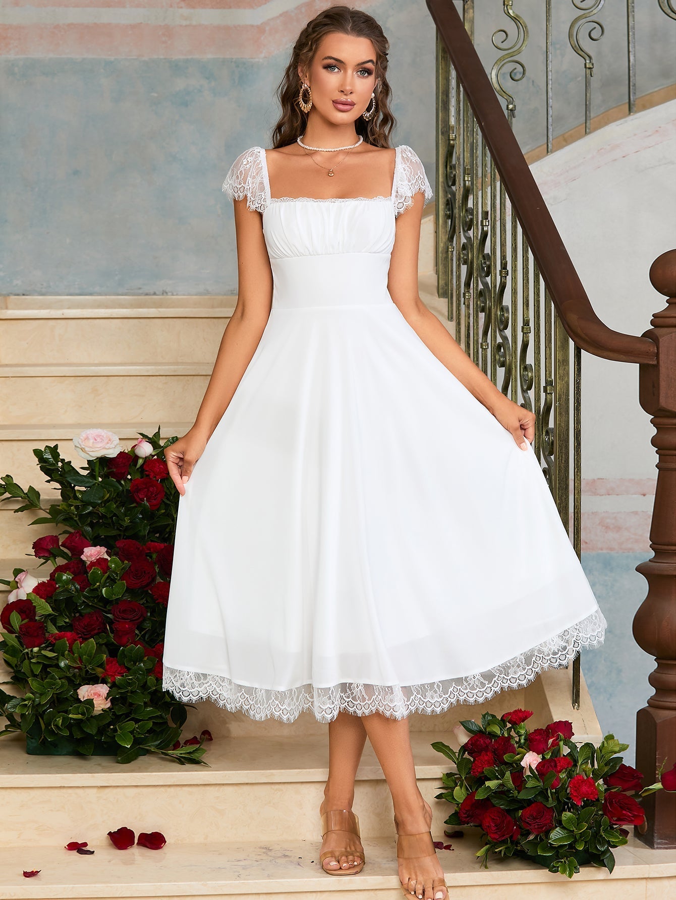 Woman in a black satin fit and flare midi dress with spaghetti straps and white lace trim.