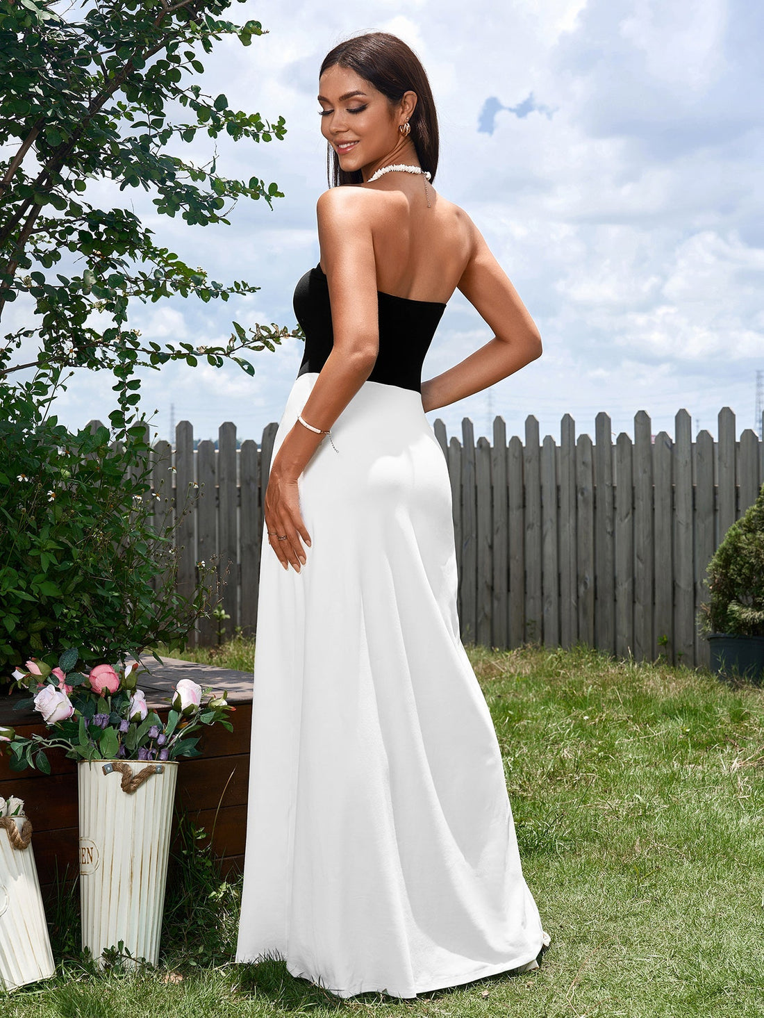 Woman wearing a black and white strapless maxi dress outdoors