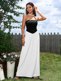 Woman in a black and white strapless maxi dress adjusting her sunglasses