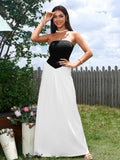 Woman in a black and white strapless maxi dress posing in a garden