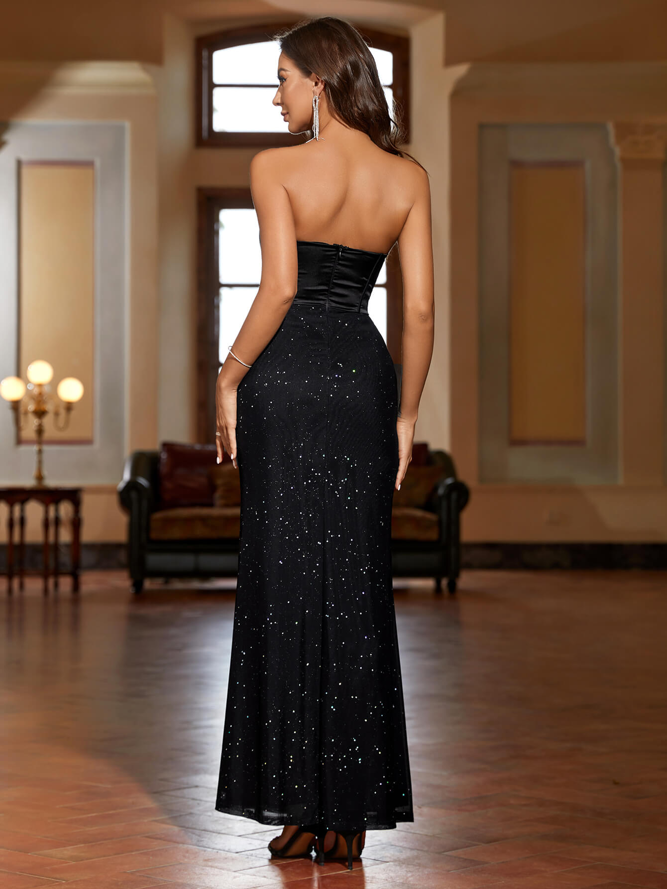 Back view of a woman in a black strapless mermaid evening gown