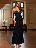 Woman posing in a black strapless mermaid evening gown with sweetheart neckline