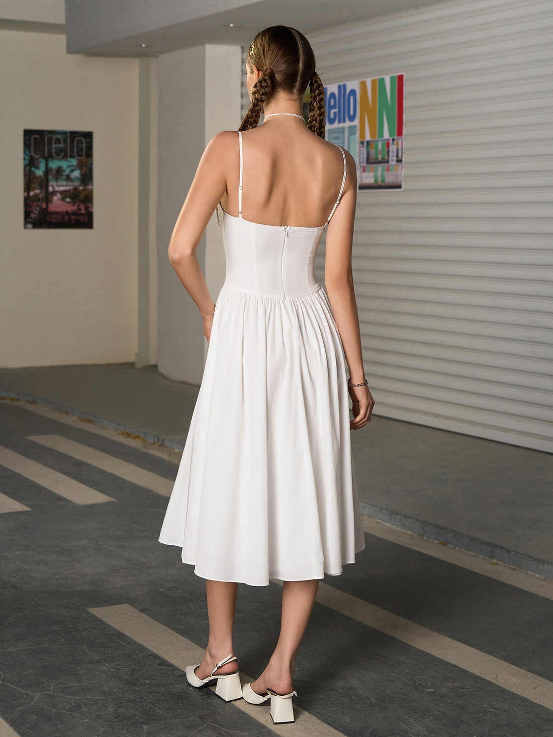 Woman wearing a white sweetheart neckline midi dress with spaghetti straps