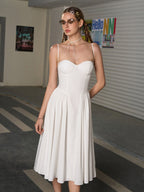 Woman wearing a white sweetheart neckline midi dress with spaghetti straps