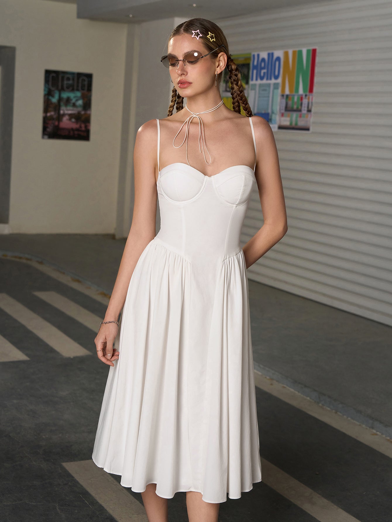 Woman wearing a white sweetheart neckline midi dress with spaghetti straps