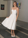 Model posing in a white fitted sweetheart neckline midi dress