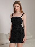 Full-body shot of a woman in a black floral jacquard sheath dress, posed with hands on hips.