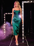 Woman walking forward in a green satin sheath dress with ruching detail.