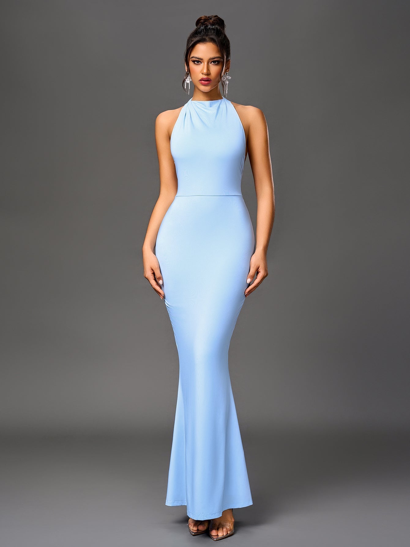 Woman wearing a light blue floor-length mermaid gown with a halter neckline.