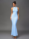 Full-body shot of a woman in a light blue halter neck mermaid dress.