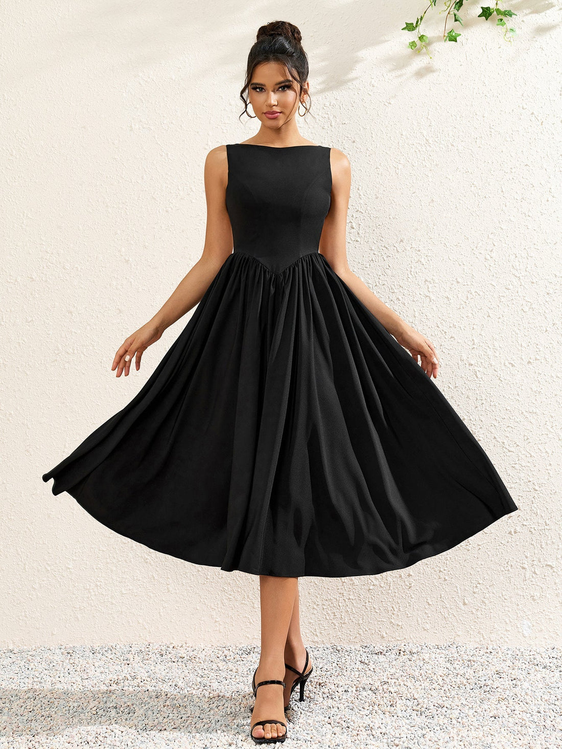 woman wearing a sleeveless black crepe midi dress with a boat neckline and flared skirt