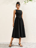 front view of a woman in a black crepe midi dress with a boat neckline and full skirt