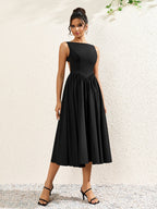 front view of a woman in a black crepe midi dress with a boat neckline and full skirt