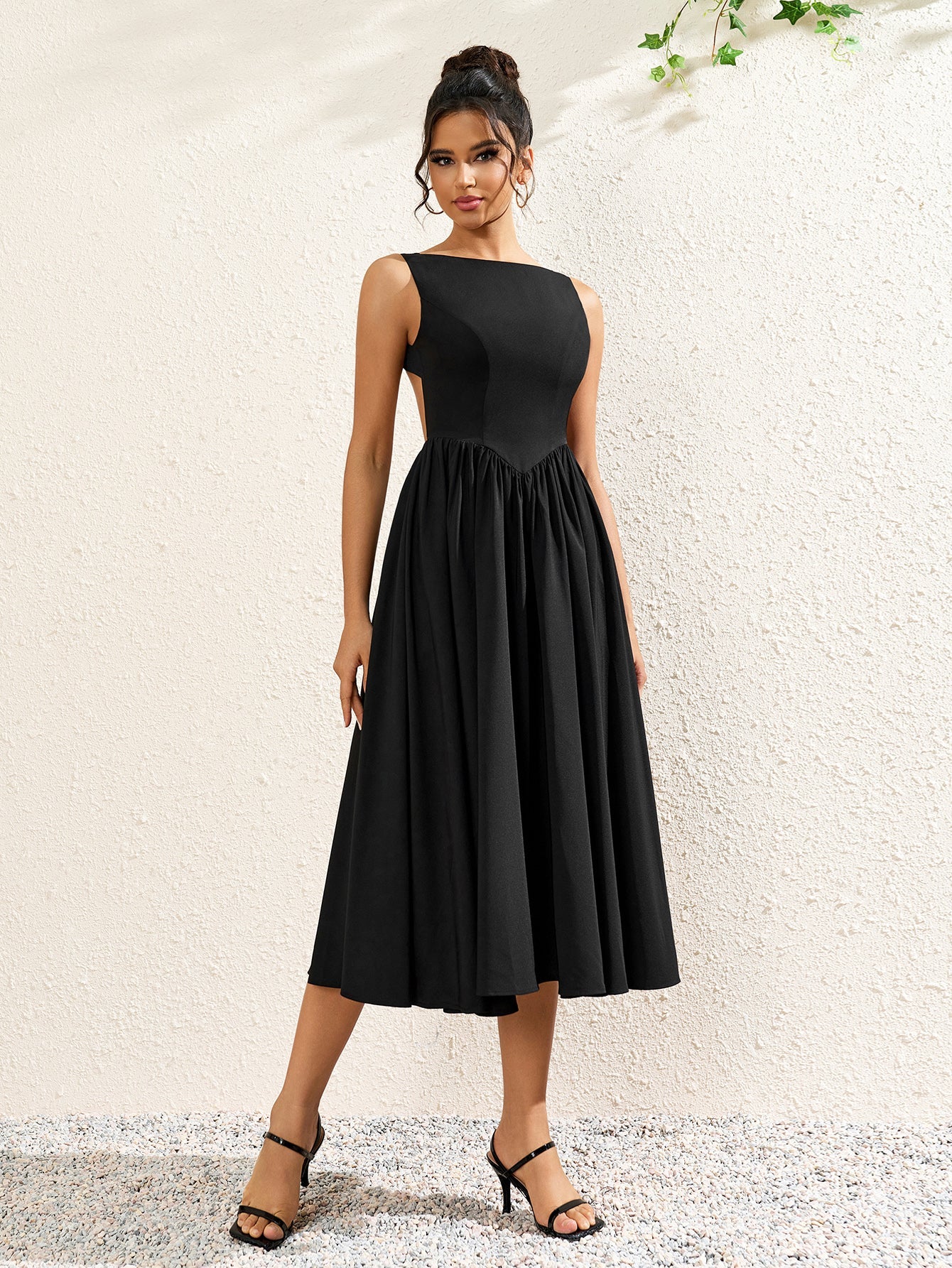 front view of a woman in a black crepe midi dress with a boat neckline and full skirt