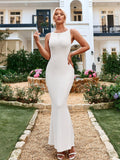 Woman wearing a white sleeveless ribbed knit mermaid gown with a scoop neckline, standing outdoors.