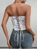 Back view of a woman in a white and blue floral print strapless corset top showing the lace-up detail.
