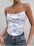 Woman modeling a white and blue floral print strapless corset top paired with denim jeans.