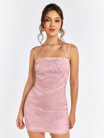 Woman wearing a pink floral jacquard sheath dress with a square neckline and spaghetti straps.