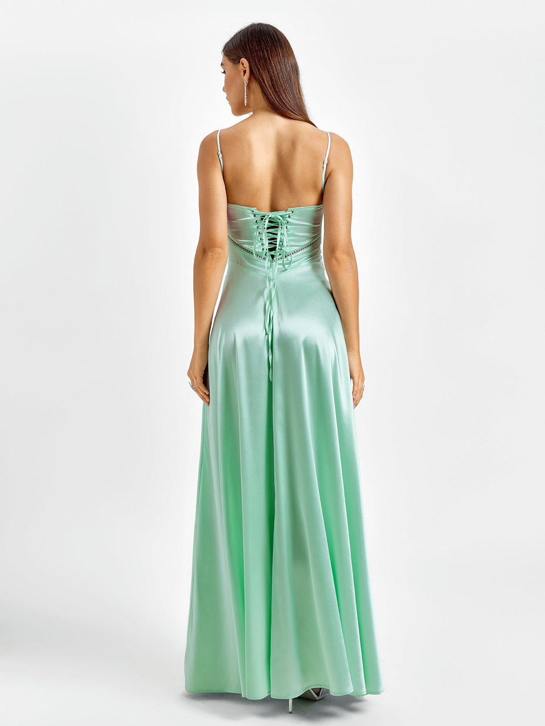 Woman in a mint green satin maxi dress with spaghetti straps and a sweetheart neckline.