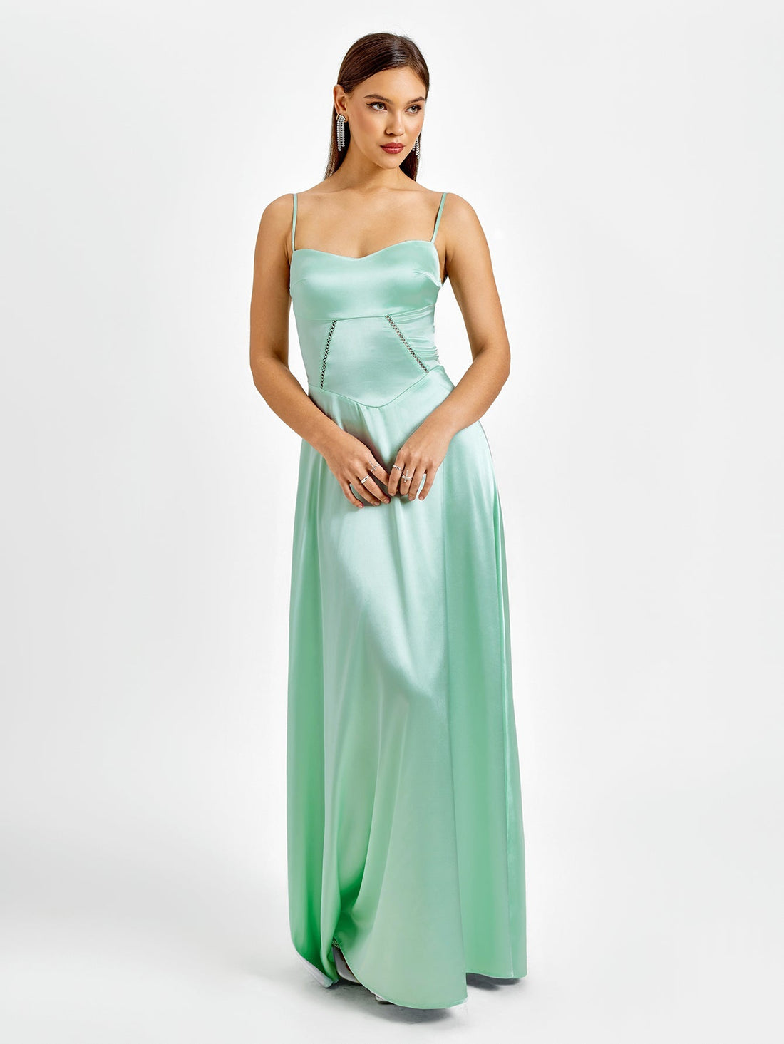 Woman in a mint green satin maxi dress with spaghetti straps and a sweetheart neckline.