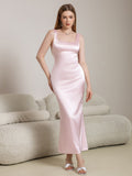 Woman wearing a pink satin maxi dress with a square neckline and spaghetti straps.