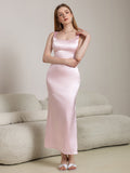 Woman posing in a pink satin maxi dress, highlighting the fabric and silhouette.