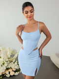Woman posing in a light blue two-piece set, touching her shoulder.