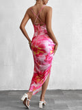 Woman wearing a pink floral print ruched bodycon midi dress with spaghetti straps and a side slit, viewed from the front.