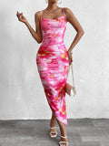 Woman wearing a pink floral print ruched bodycon midi dress with spaghetti straps and a side slit, showing detail of the ruched fabric.