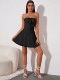 Full body shot of a woman in a black strapless corset dress