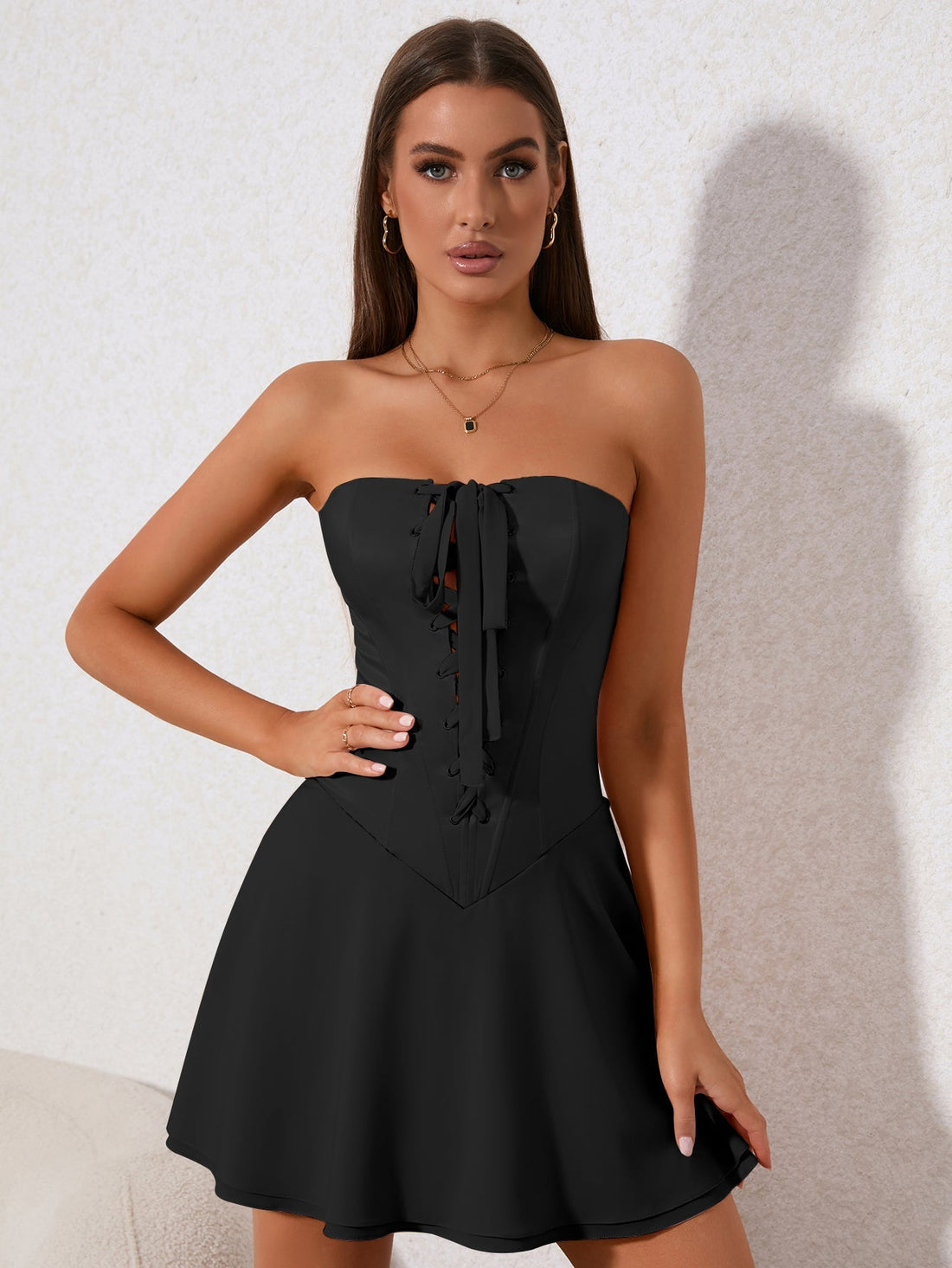 Woman in a black strapless corset dress with lace-up front detail