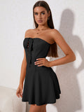Woman posing in a black strapless corset dress