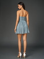 back view of a woman in a blue strapless party dress