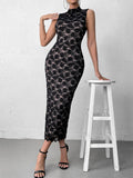 Woman leaning on a stool while wearing a black lace midi dress