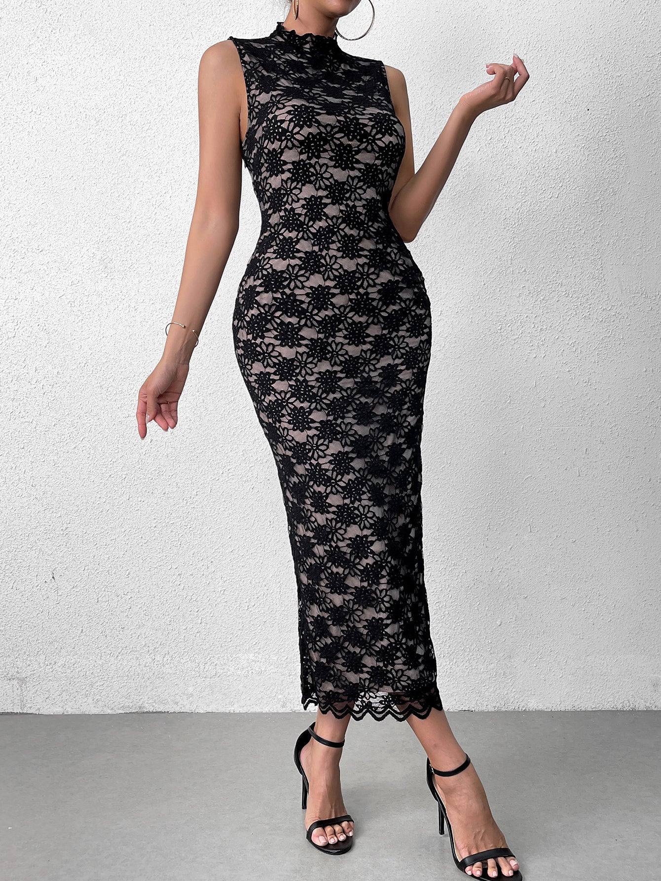 Front view of a woman posing in a black lace sheath dress