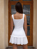 Back view of a woman in a white textured knit mini dress