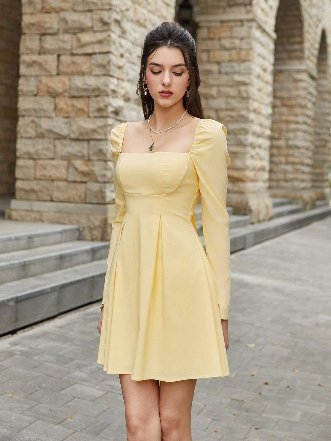 Woman wearing a yellow puff sleeve square neck mini dress