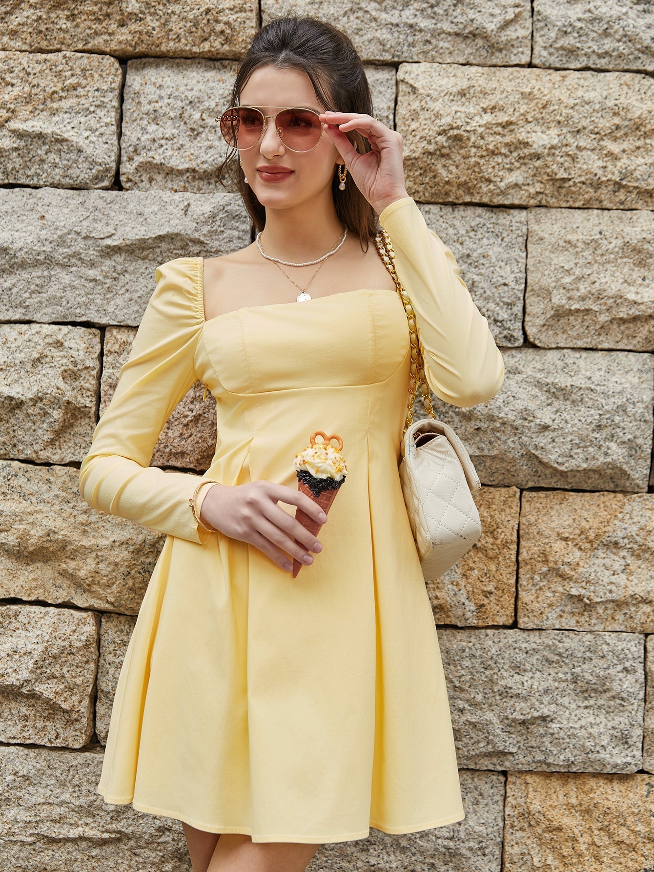 Woman in a yellow puff sleeve square neck mini dress holding an ice cream cone