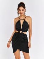 Woman wearing a black halter neck mini dress with cut-out waist detail and a ring accent.