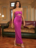 Full-length front view of a woman in a magenta strapless column gown with a cutout bust and high slit