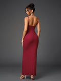 Rear view of a woman in a floor-length, deep red evening gown featuring spaghetti straps and a fitted silhouette with subtle sparkling embellishments.