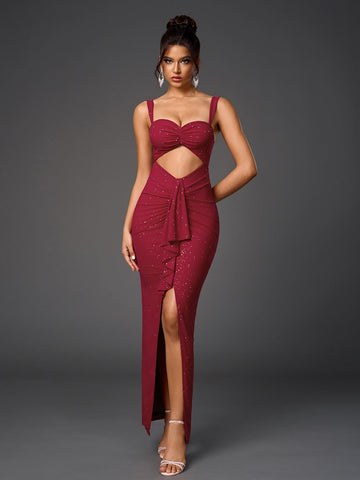 Woman wearing a floor-length, form-fitting, deep red dress with a sweetheart neckline, spaghetti straps, a midriff cutout, ruched detailing, and a high slit, adorned with subtle sparkling embellishments.