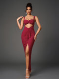 Front view of a woman posing in an elegant, floor-length, deep red evening dress with a sweetheart neckline, spaghetti straps, a cutout, ruched fabric, and a high slit, featuring sparkling accents.