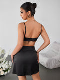 Woman wearing a fitted black lace trim cami dress