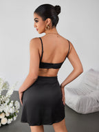Woman wearing a fitted black lace trim cami dress