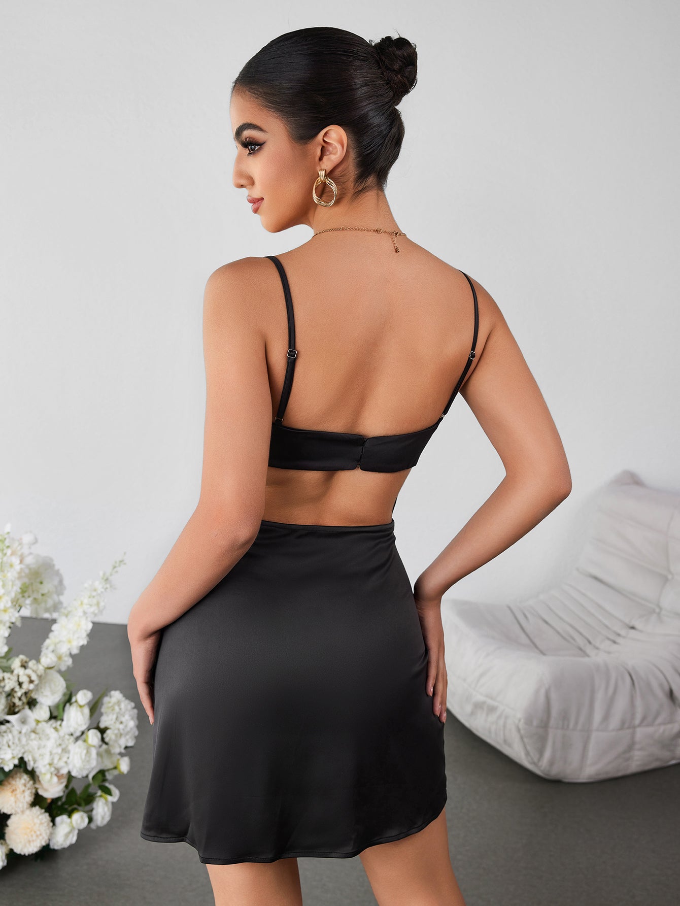 Woman wearing a fitted black lace trim cami dress